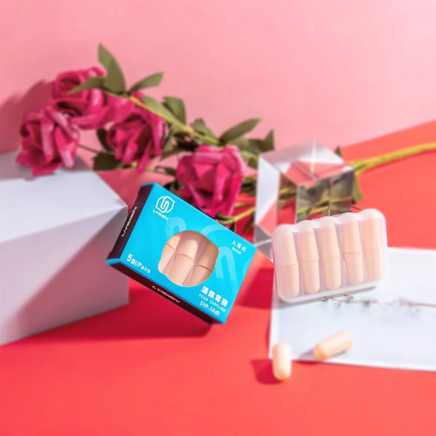 Retail packaging for foam earplugs photographed on a styled set
